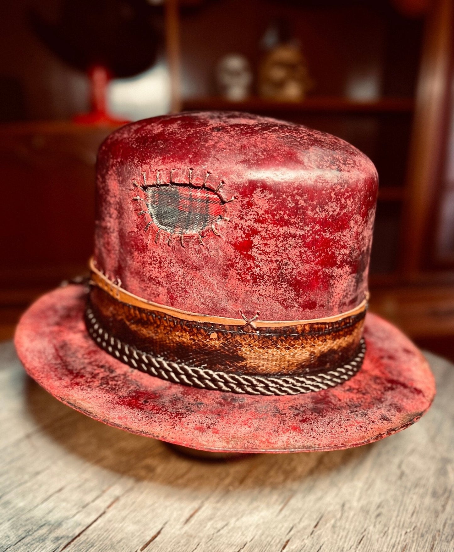 Red artisanal open crown hat with distressed finish and decorative band by JonHats