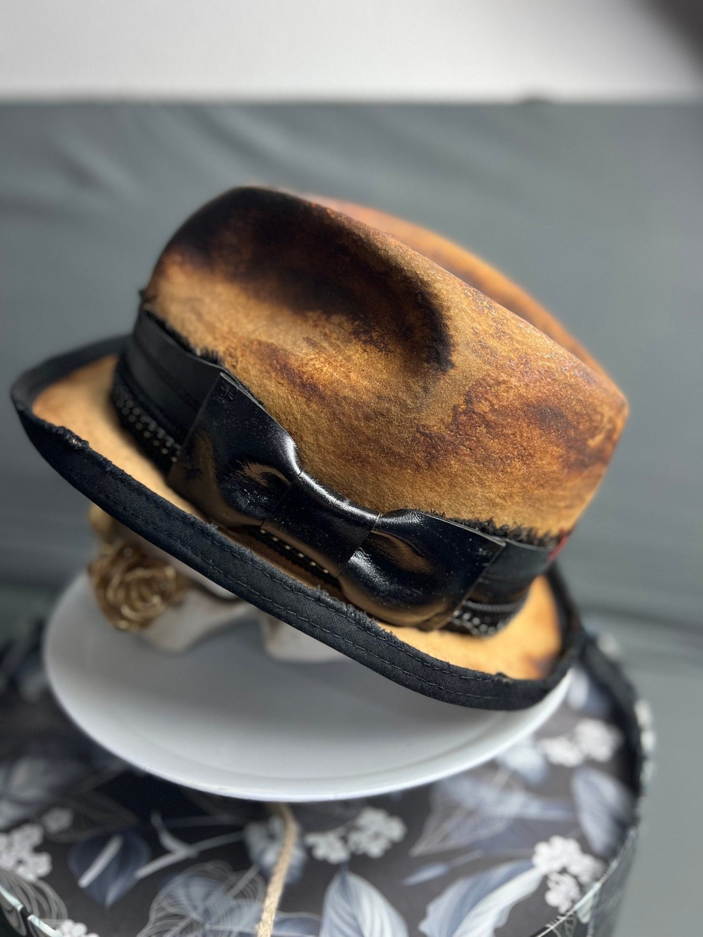JonHats boho vintage distressed hat with black leather band and bow detail in brown tones