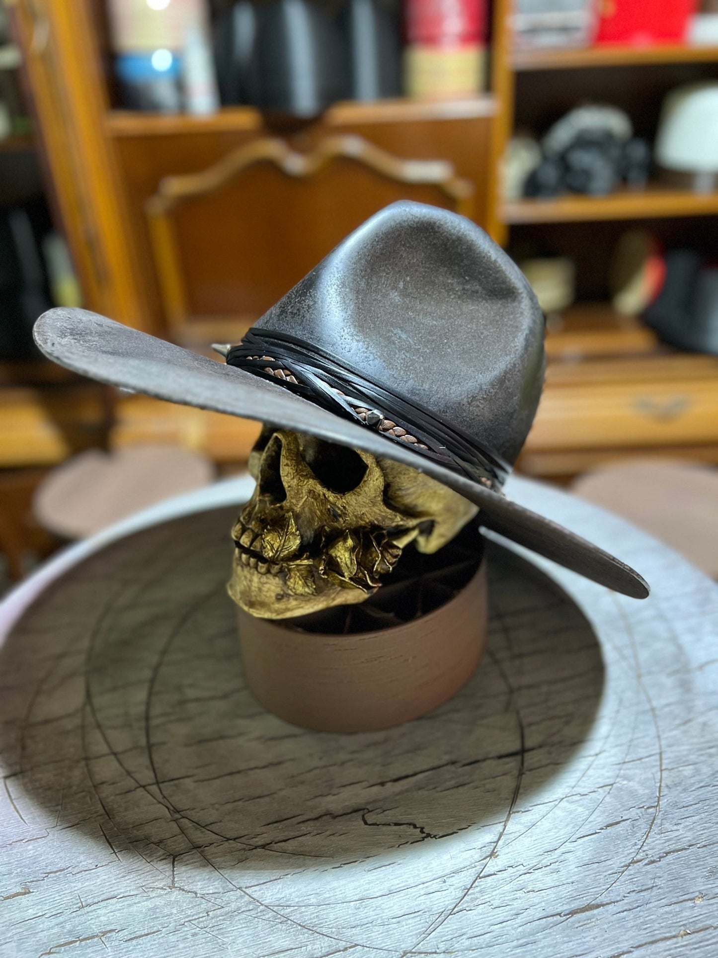 Handmade punk apocalyptic hat in grey leather style displayed on skull stand by JonHats