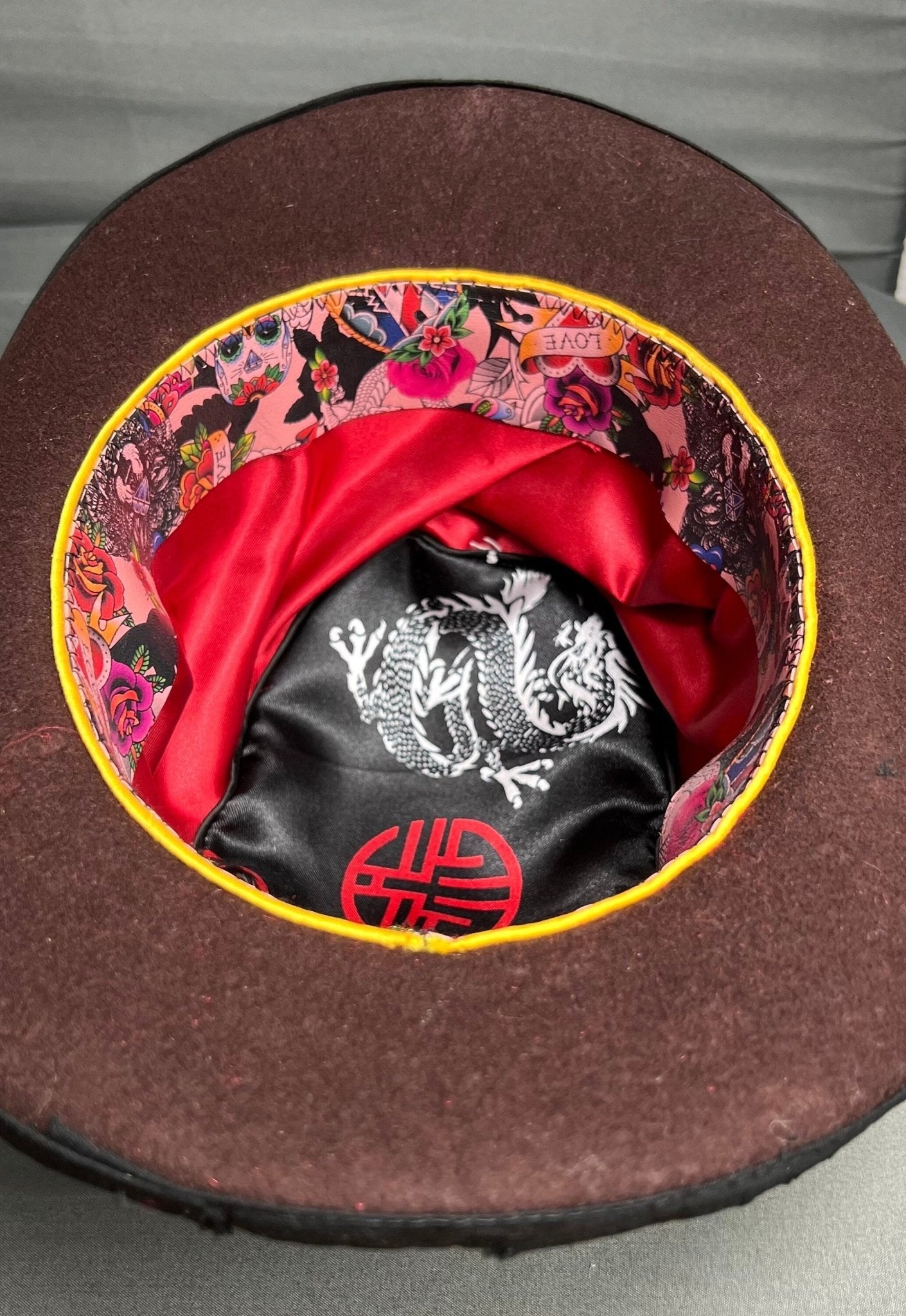 Inside view of a JonHats handmade vintage bowler hat showing colourful floral lining and red satin interior
