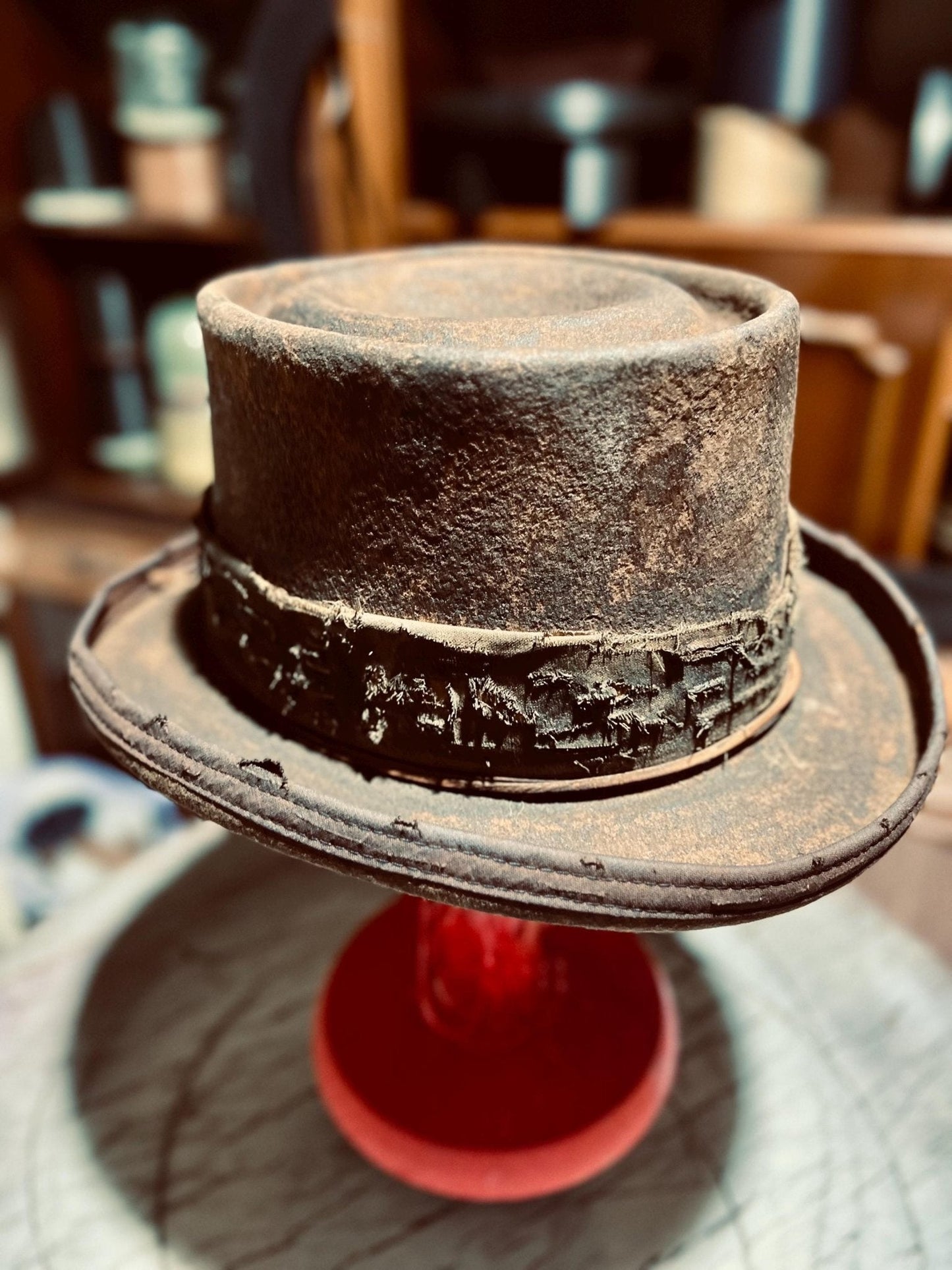 JonHats handmade western hat with distressed leather and rustic detailing on display