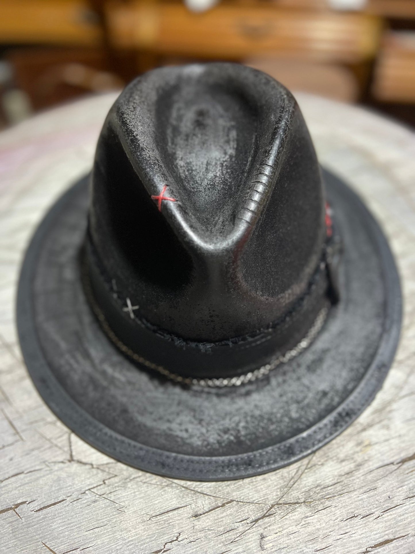 Black Las Vegas style vintage hat with decorative stitching by JonHats on a wooden surface