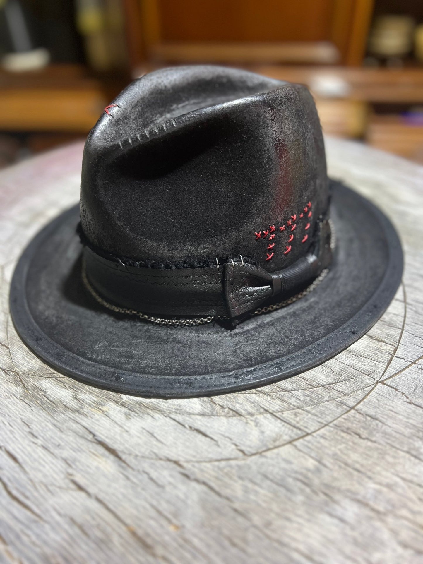 JonHats black Las Vegas style vintage hat with stitched red details and leather band on wooden surface