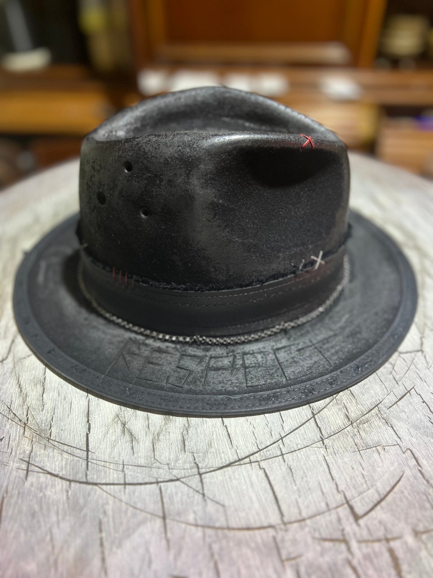 Black JonHats Las Vegas style vintage hat with distressed finish and stitched detailing on wooden surface