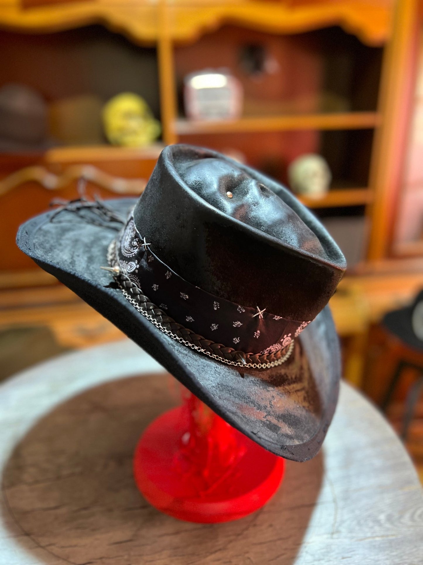 JonHats skull themed cowboy hat in black with decorative band and chain detail on display