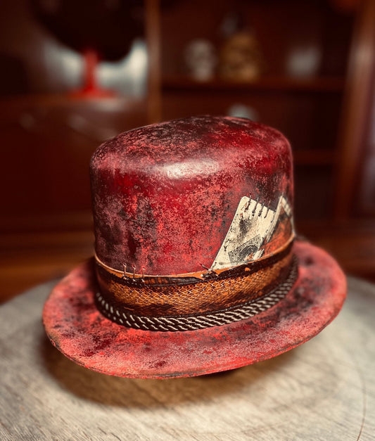 Red artisanal open crown hat by JonHats with textured finish and decorative leather band