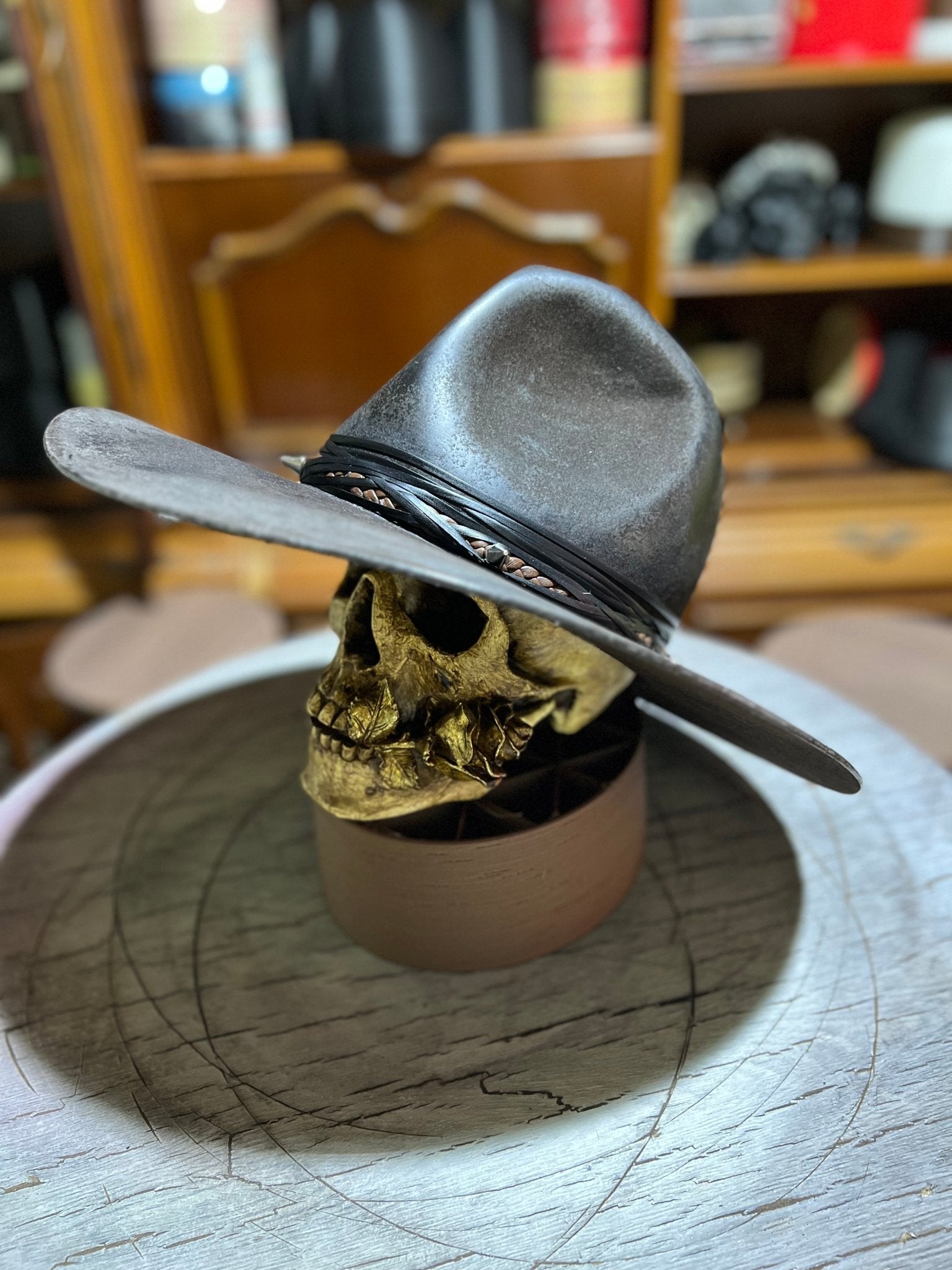 Handmade punk apocalyptic hat in grey leather style displayed on skull stand by JonHats