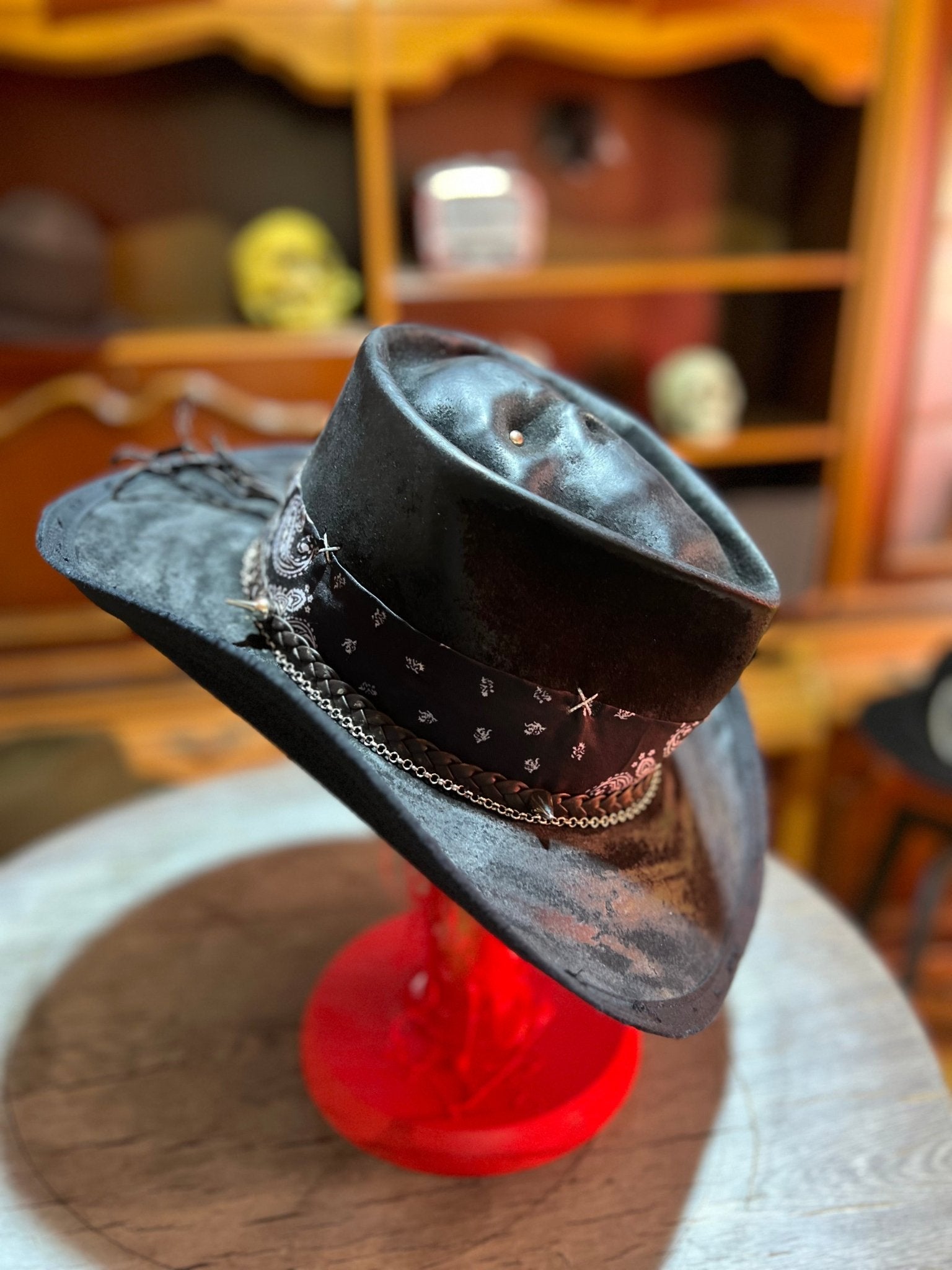 JonHats skull themed cowboy hat in black with decorative band and chain detail on display
